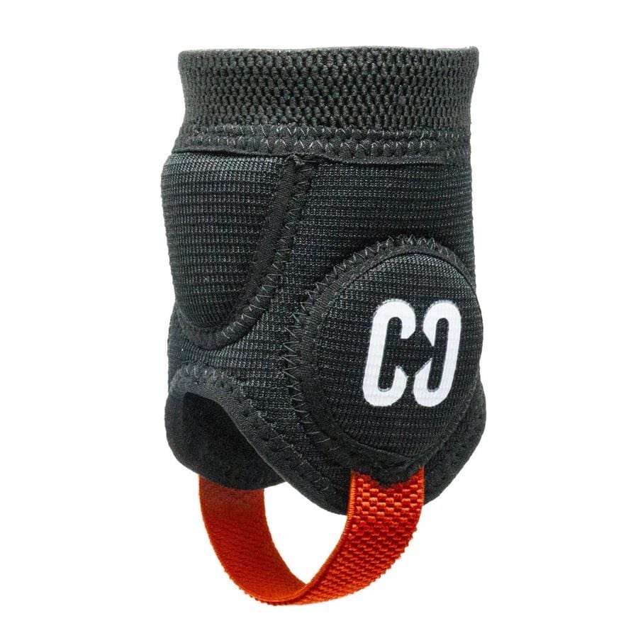 A close-up of the CORE Ankle Skate Protection Guards in black fabric shows Velcro straps for support, ideal for extreme sports. It features a red pull tab and displays a white "CD" logo on the side. The textured surface offers durability and comfort, making it perfect for scootering enthusiasts who need reliable ankle protection.