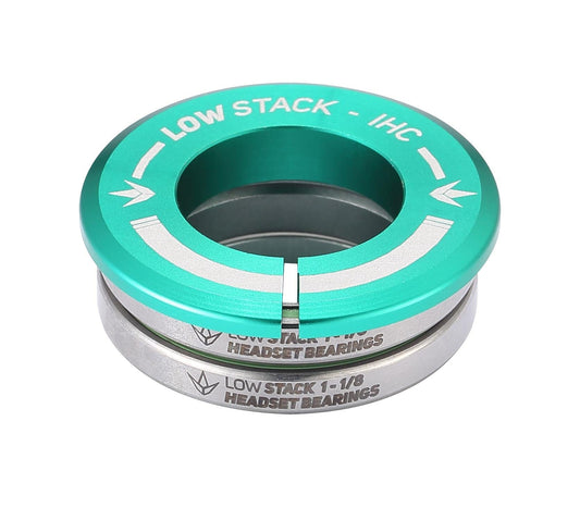 The Blunt Envy Low Stack IHC Integrated Stunt Scooter Headset in teal features sealed bearings and a distinctive arrow symbol. Its "LOW STACK - IHC" and "LOW STACK 1-1/8 HEADSET BEARINGS" labeling enhances its compatibility with the Blunt Envy Stunt Scooter, offering a sleek metallic finish through neatly stacked components.