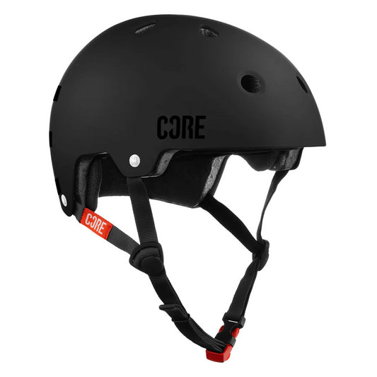 The CORE Street Skate/Scooter Helmet in Stealth Black by CORE features a sleek design with ventilation holes and a red adjustable chin strap, providing both comfort and style. Set against a white background, its sturdy build is emphasized, further enhanced by Lux Pads for extra protection during cycling or skateboarding excursions.