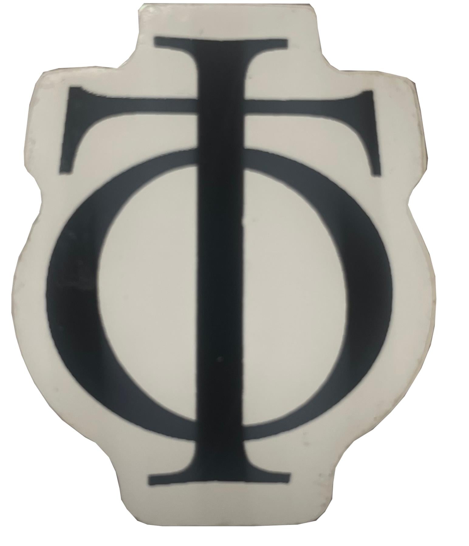 A sticker in the shape of a shield displays a prominent black "T" overlapping the "O" against a clean white background, similar to the Oath Logo Sticker - Black by the brand Oath.