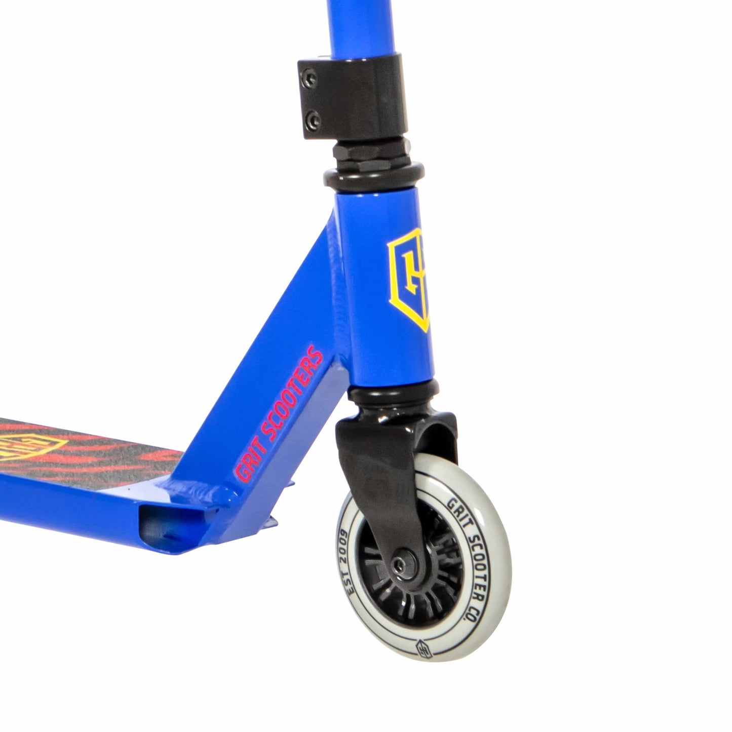 Close-up of a blue scooter's front wheel and frame. The wheel features a black hub with a white outer rim displaying "Grit Scooters." The Grit Atom 2021 Kids Complete Stunt Scooter - Blue is ideal for beginners, showcasing a sleek frame with a "G" logo and branded deck.