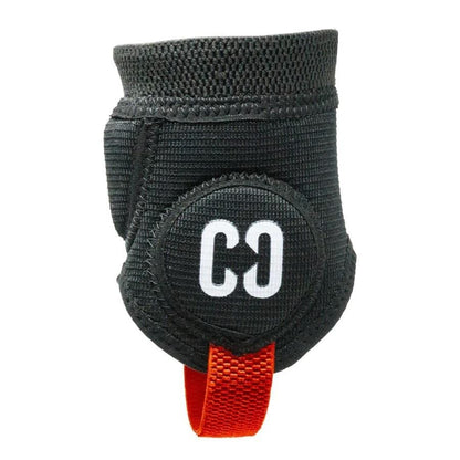 The CORE Ankle Skate Protection Guards in black, featuring a circular "C0" logo in white, include a red strap for secure fastening. Designed with a flexible and durable texture, these guards are perfect for sports such as scootering or BMXing, offering essential support and protection.