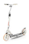 The Frenzy 205mm Dual Brake V4 Foldable Commuter Scooter in cream offers a sleek design with large wheels and features black grip tape, branded "Frenzy," on the deck. It has beige handlebar grips and is designed for convenience with its foldable structure, complemented by a dependable rear wheel brake for enhanced safety.