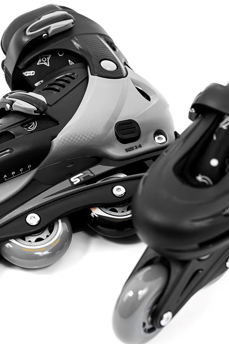 Close-up image of SFR Cyclone II Adjustable Inline Skates - Ninja in black and gray, highlighting the wheels and clasps. These SFR skates offer adjustable sizing ideal for beginner skaters, with rollerblades positioned at different angles to emphasize their sleek design and texture against a white background.