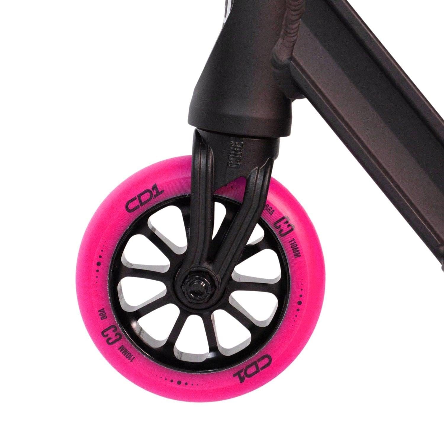 Close-up of a scooter wheel with vibrant pink tires, ideal for both stunt scooter enthusiasts and beginner riders. Attached to a sleek black frame, the tire features the "CORE CD1" label and is sized at 100mm. The spoke design seamlessly enhances the sturdy aluminum deck of the CORE CD1 Complete Stunt Scooter - Pink / Black.