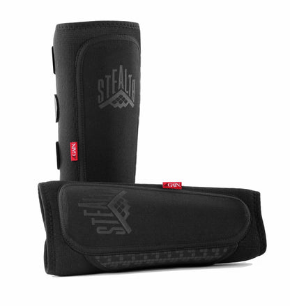 Two sleek GAIN Protection Stealth Shin Guards in black are displayed. One guard stands upright, showcasing the GAIN logo, while the other is positioned horizontally to reveal the fastening straps. Each guard features a modern, textured design made with breathable neoprene and is adorned with visible red tags that read "GAIN.