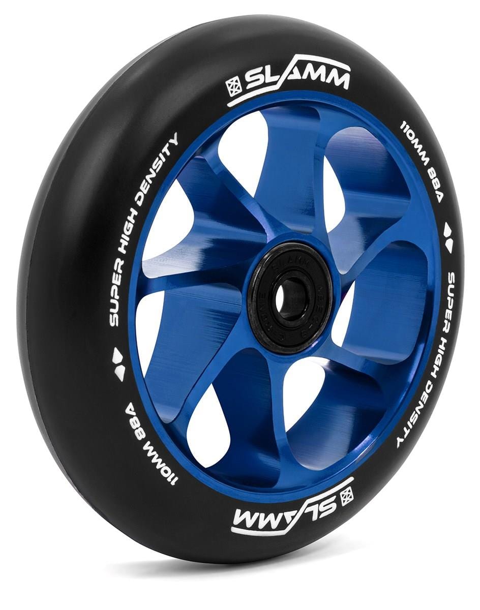 The Slamm Team 110mm Stunt Scooter Wheel in blue features a spoked design with a central hub and an aluminum core. It is constructed with high-rebound PU material for improved performance, and the rubber edge displays white text reading "SLAMM" and "SUPER HIGH DENSITY.