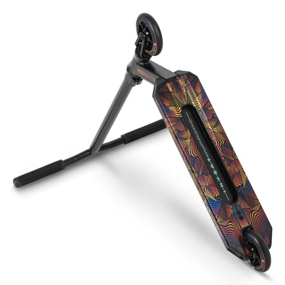 The Invert Supreme Journey 2.5 Jamie Hull Stunt Scooter - Full Mental Sunset is propped up at an angle, resembling a traditional skateboard with its black handlebar stand. The deck features eye-catching geometric patterns in vibrant red, yellow, and blue hues. Designed for perfect trick sessions, its sleek black wheels are ideal for intermediate riders.