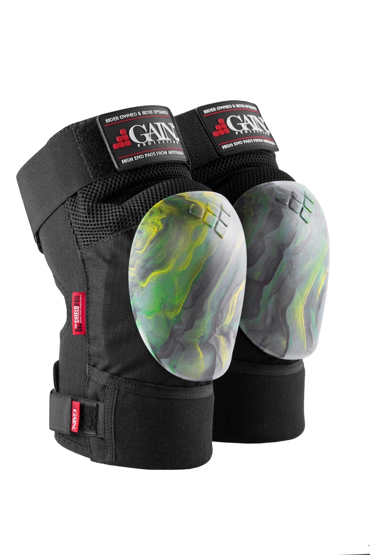 Introducing the GAIN Protection The Shield Pro Knee Skate Pads in a stylish gold and green colorway. These knee protectors feature durable marbled hard caps, perfect for heavy-duty use and ideal for freestyle scootering. The brand name, GAIN, is prominently displayed on the upper part of the pads.