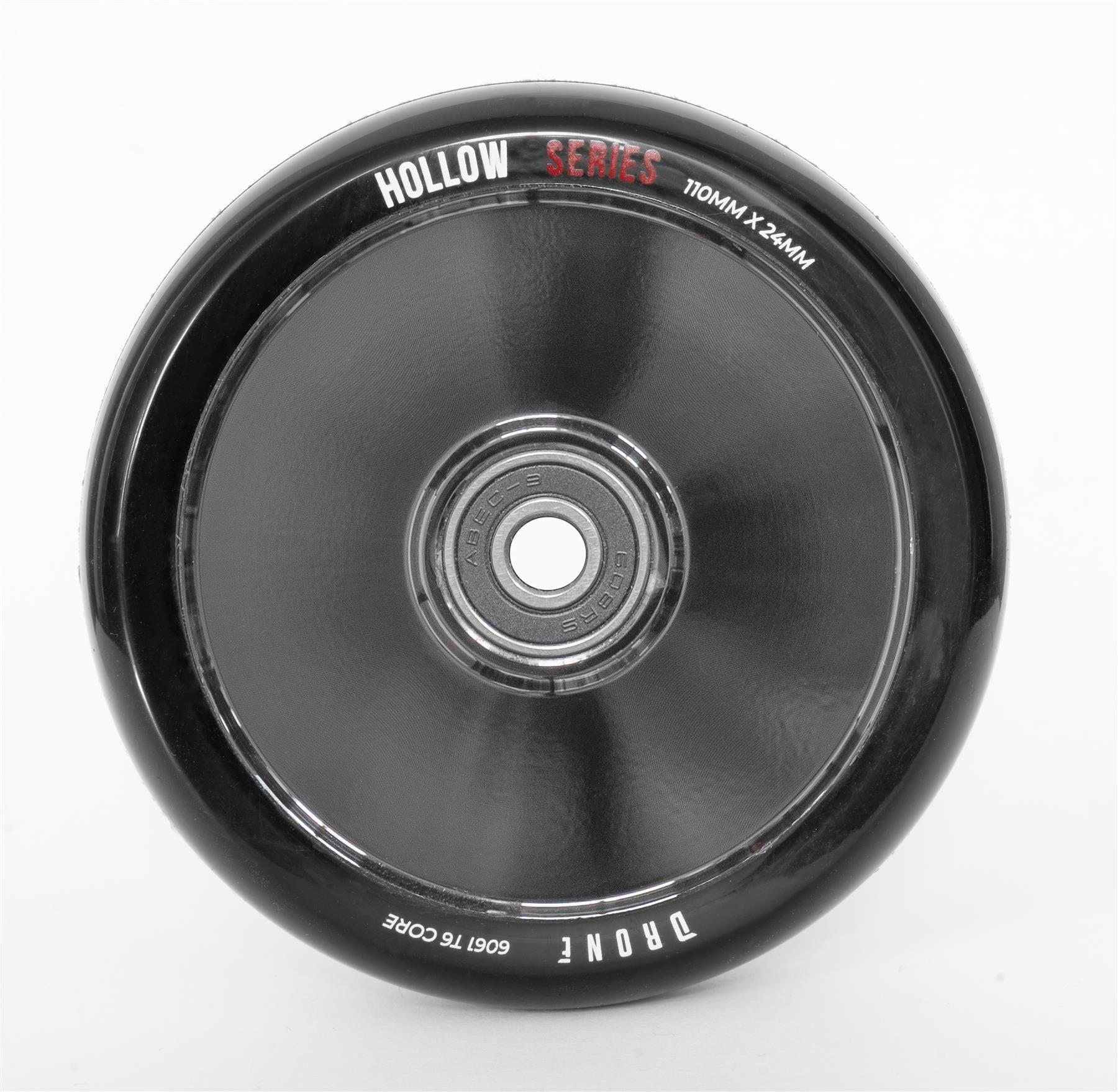 The Drone Hollow Series 110mm Stunt Scooter Wheel in Smoked Chrome features a metallic center bearing and black rim with "110MM x 24MM" and "6061 T6 Core" seen from above. Labeled "Hollow Series" and "Tronic," it's perfect for stunt scooter enthusiasts seeking high-quality design.