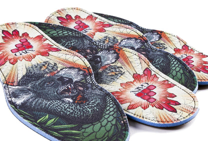 The GAIN Protection SoleBros Insoles - Dropbear, created by GAIN, offer vibrant and shock-absorbing features with a colorful illustration of a winged koala. Ideal for freestyle scooter riders, these insoles also display red sunburst patterns and a geometric logo featuring the letters "CA.M" in the center, combining style with efficient energy absorption.