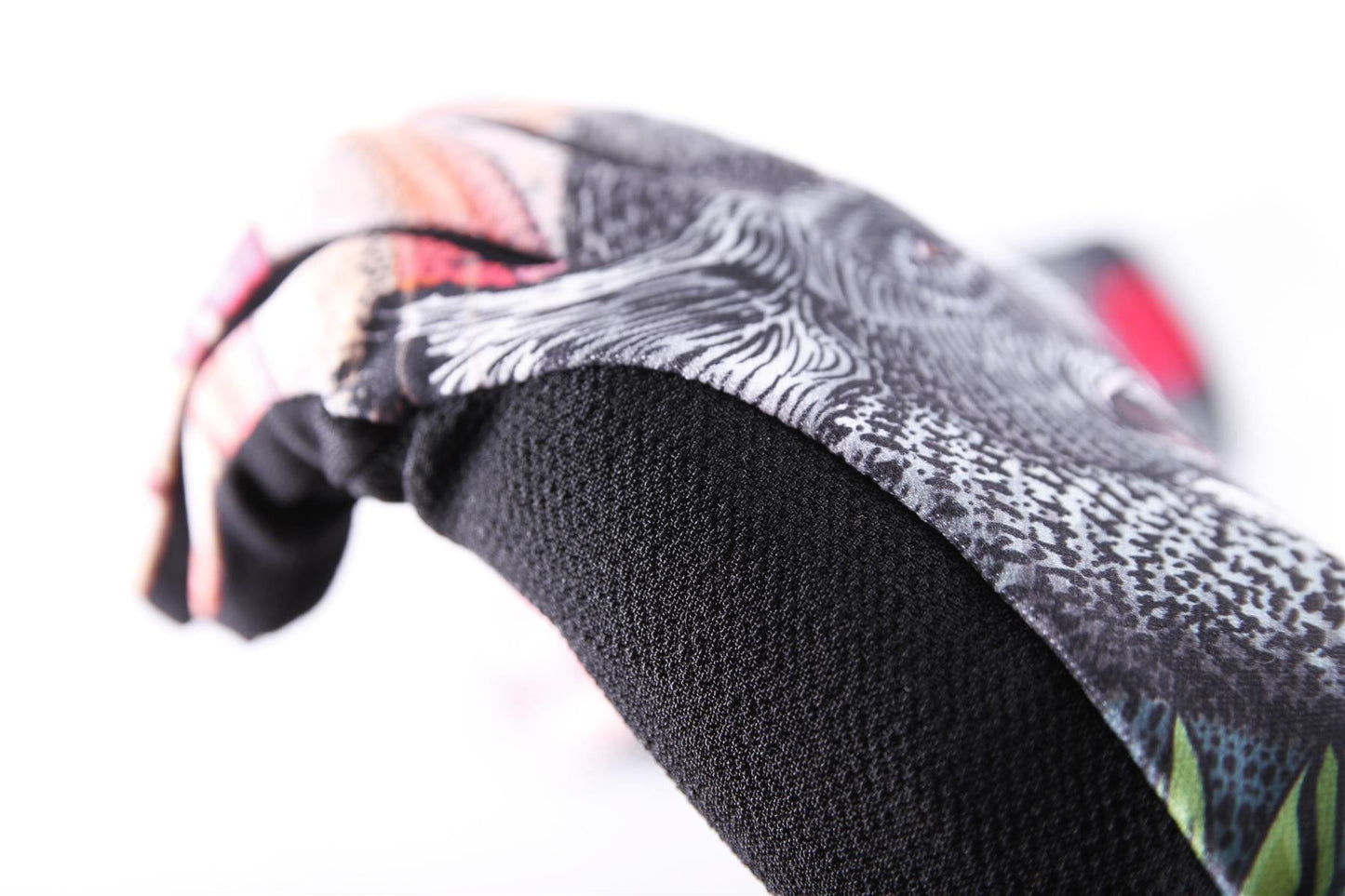 Close-up of a textured fabric showcasing GAIN's ARMORTEX fabric from the Protection Resistance Skate Gloves - Dropbear. The design features intricate white and pink patterns, creating an abstract appearance against the smooth black surface beneath, ideal for resistance gloves.