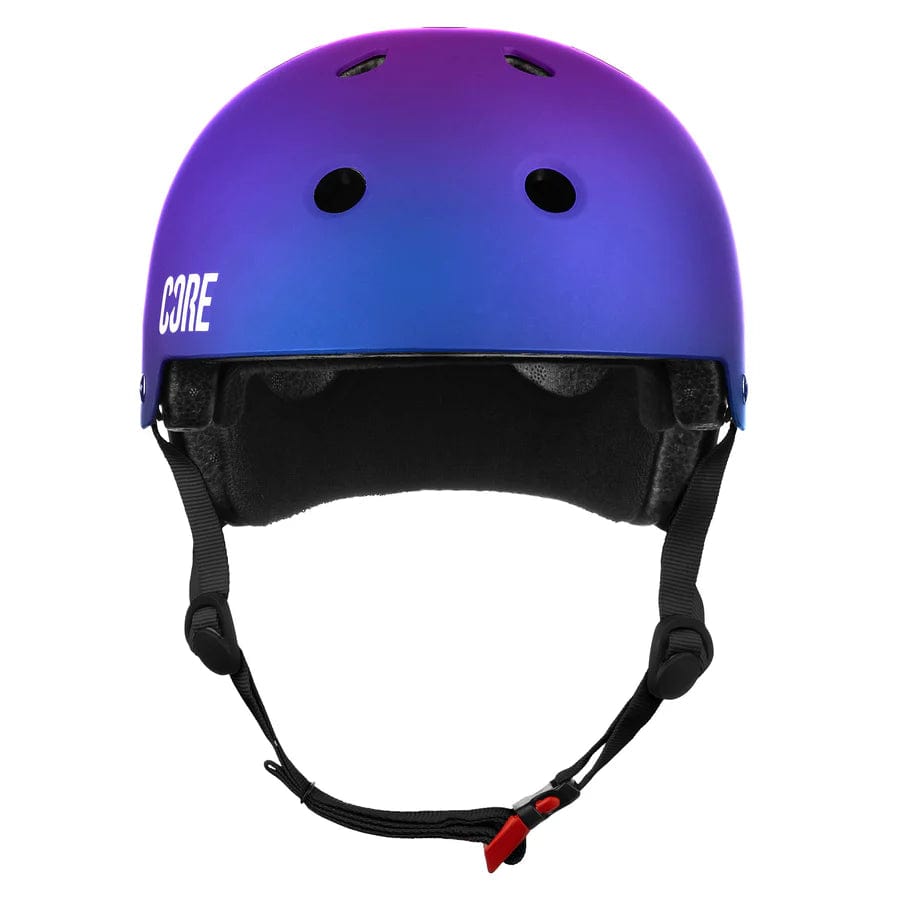 The CORE Street Skate/Scooter Helmet - Neo/White boasts an eye-catching gradient design transitioning from purple to blue, complemented by black interior padding and Lux Pads for added comfort. It features ventilation holes and an adjustable chin strap, with the "CORE" logo prominently displayed on the side in white letters.