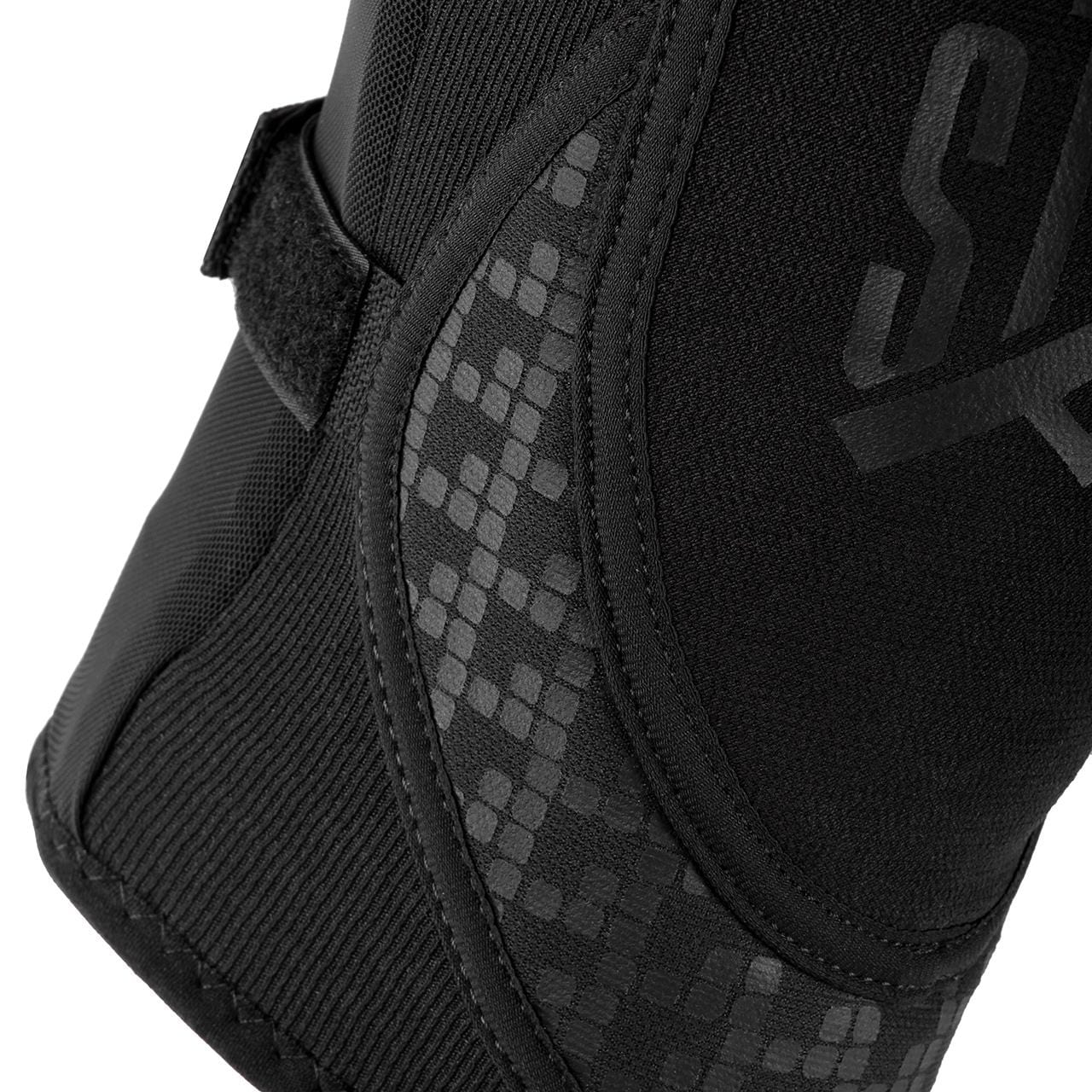 A close-up view of the GAIN Protection Stealth Knee Skate Pads in black, designed with shock-absorbing capabilities, includes a velcro strap and textured pixel-like patterns. The durable fabric displays noticeable stitching along the edges to provide enhanced knee protection.