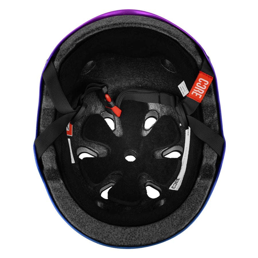 The image displays the interior of the CORE Street Skate / Scooter Helmet - Neo / White, highlighting its black padding, ventilation holes, and adjustable straps. Red and white "CORE" tags stand out, emphasizing its premium design similar to Lux Pads for enhanced comfort and protection.