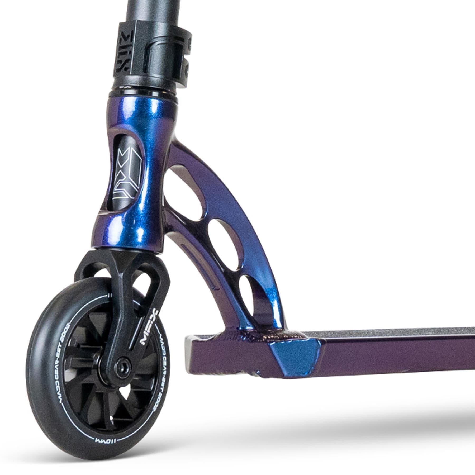 The MGP VX Origin III 500 Complete Stunt Scooter by Madd Gear (MGP) showcases a front fork with a dark blue metallic finish and geometric cutouts. Its wheel features a black spoke design with white lettering, while the robust deck is visible, highlighting its durability for adventurous rides.