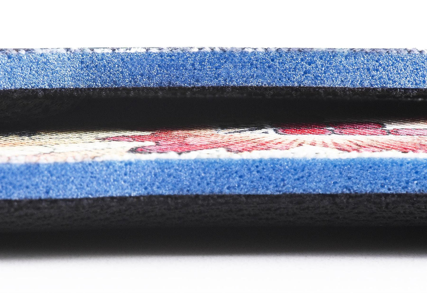 A close-up of a textured, multicolored fabric strip bordered by blue and black layers resembles the craftsmanship components found in GAIN Protection SoleBros Insoles - Dropbear. It displays detailed stitching and a vibrant pattern designed for impact energy absorption, making it an ideal choice for freestyle scooter riders looking for both style and safety.