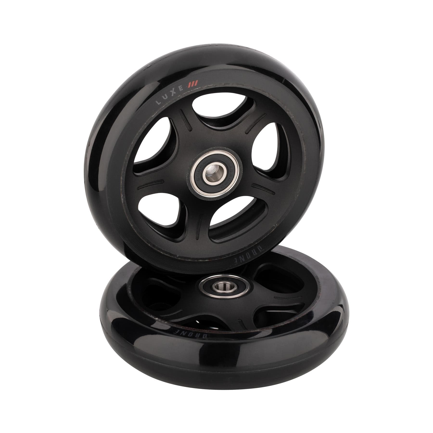 Two Drone Luxe 3 Dual-Core 110mm Stunt Scooter Wheels from Drone in black are set against a white background. One wheel stands upright, the other lies flat. Both have five spokes and a gleaming metallic center bearing, showcasing their sleek design for an impressive ride.