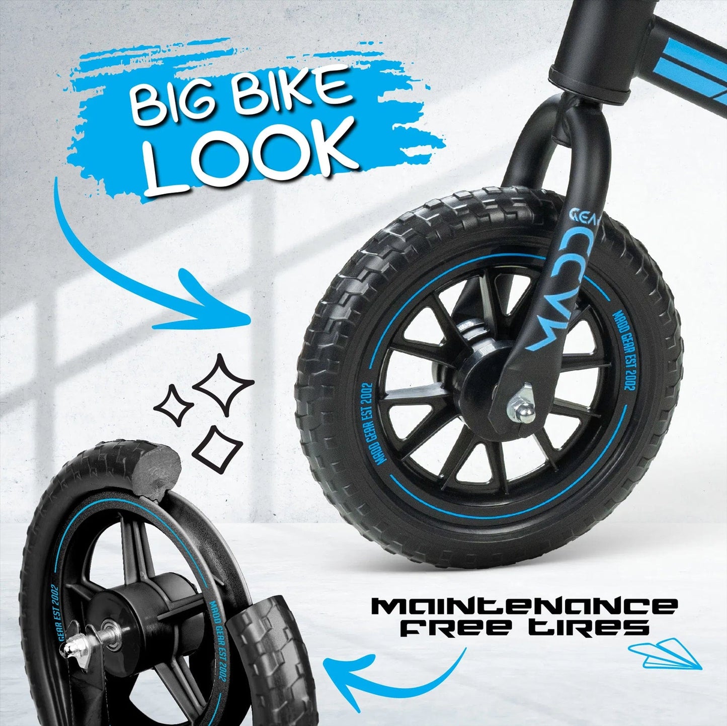 A close-up of the front wheel of the Madd Gear My 1st BMX Balance Bike - Black / Blue by MGP, showcasing "Big Bike Look" and "Maintenance Free Airless Tyres," with black tires featuring blue accents. Illustrated arrows and sparkles enhance the image.