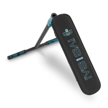 A diagonally leaning pole with a teal blue tip, designed like a stunt scooter by Invert, is attached to a rectangular padded black mat branded as the "Invert Supreme Launch Tramp Trainer" in teal blue text. The mat includes a logo above the text.