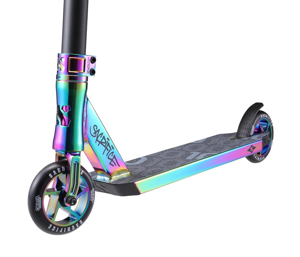 A close-up view of the Sacrifice Flyte 100 V2 Complete Stunt Scooter - Neochrome by Sacrifice highlights a colorful kick scooter with a vibrant iridescent frame and a textured black deck for grip. This pro scooter features two wheels with sleek, multicolored rims and a rear fender brake for agile riding.