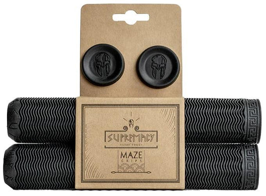 Supremacy Maze Black Stunt Scooter Grips, measuring 180mm, come with a Greek key pattern and wavy texture in black. This durable product, ideal for pro riders, includes two matching bar end plugs. They are packaged in cardboard that displays the Supremacy logo featuring a helmet.