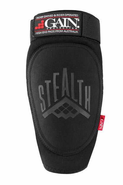 Introducing the GAIN Protection Stealth Elbow Skate Pads in black, featuring "STEALTH" printed on the front. Enhanced with a KEVLAR layer for extra durability, it is crafted from DuraTec neoprene. It showcases its Australian origin with a top label reading "GAIN Protection" and includes a small red tag marked "NDP" on the edge.