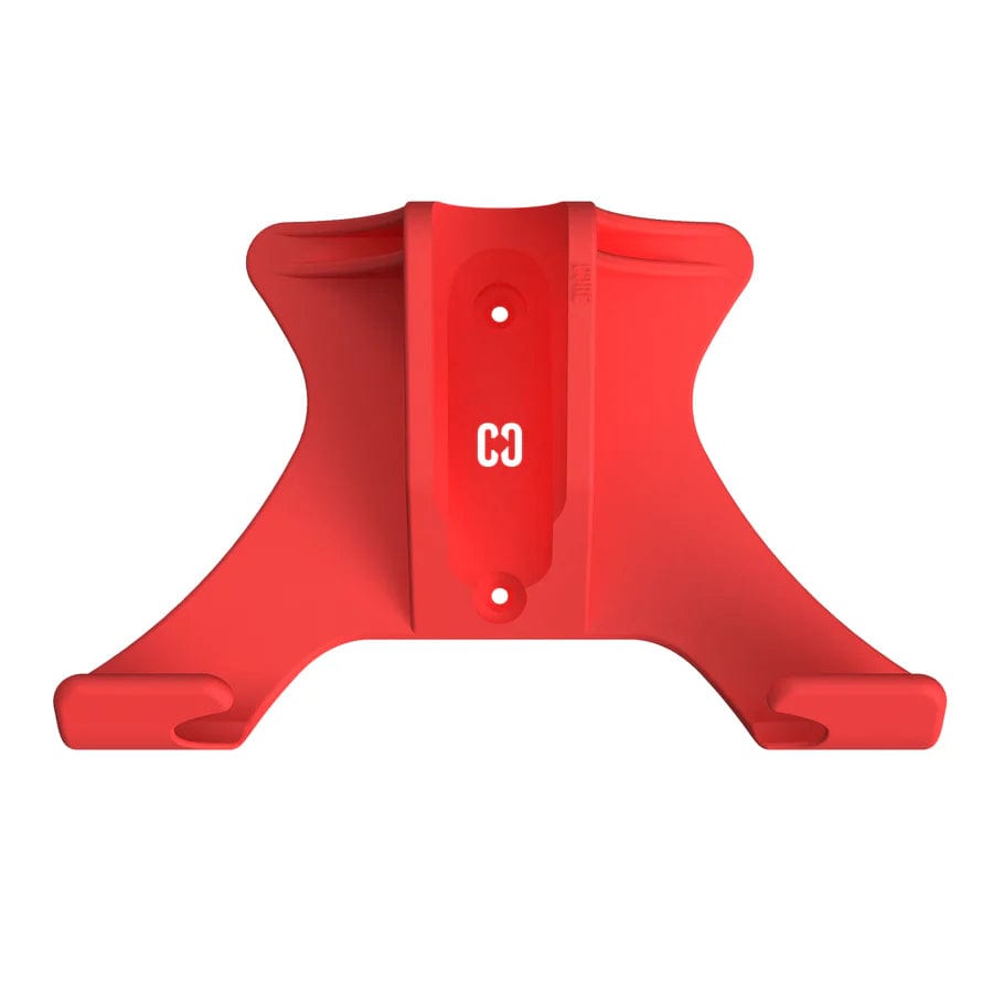 The CORE Scooter Wall & Floor Stand by Skates.co.uk features a red plastic design with central alignment in the shape of an inverted "T" and two hooks on each side for holding or hanging items. It also boasts a curved design and has a small engraved logo in the center.