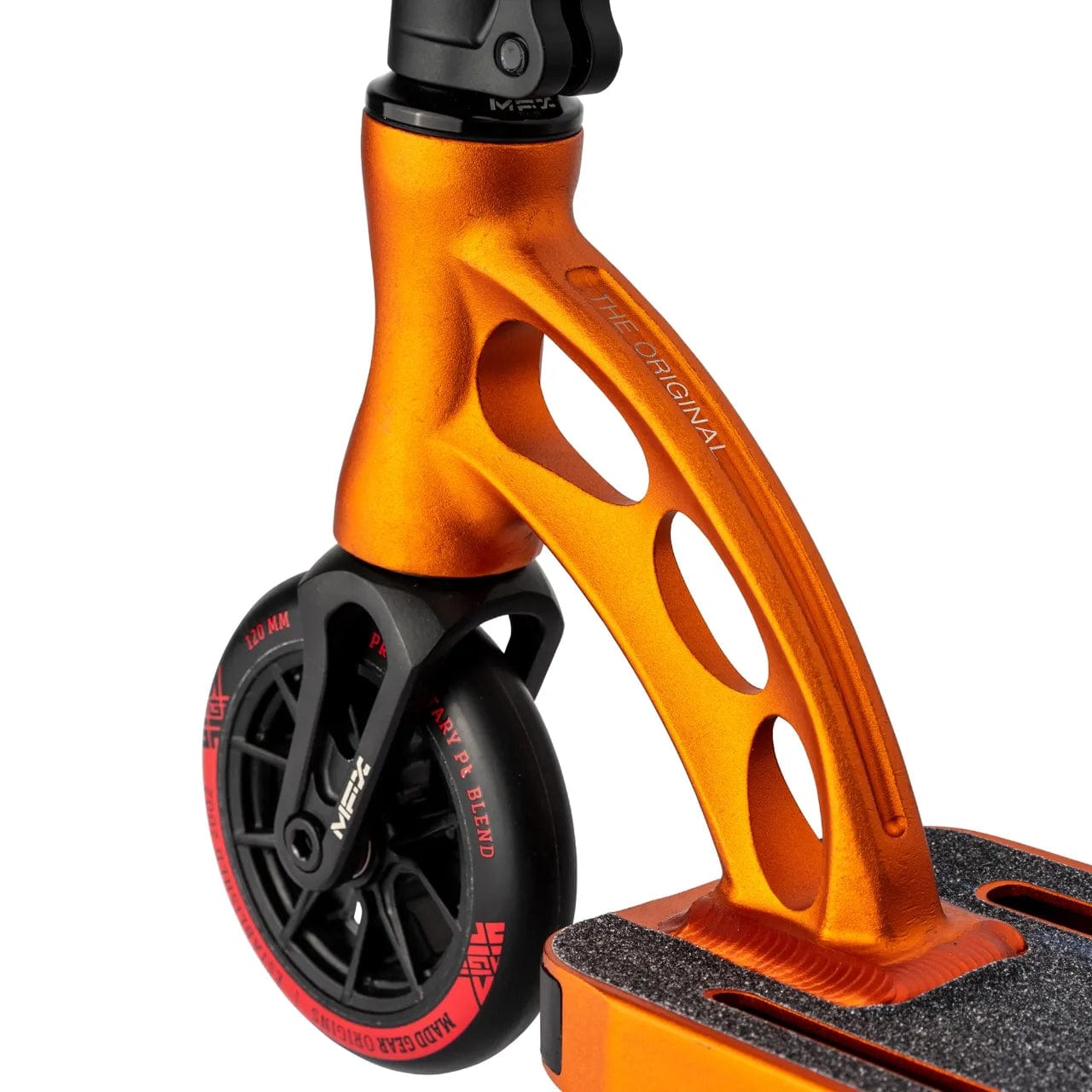 Close-up of the Madd Gear MGP VX Origin Team Edition Complete Stunt Scooter's orange front wheel, showcasing a sleek design with angular cutouts. The black tire features distinctive white and red markings, while the durable deck is textured for added grip, ensuring reliable performance.