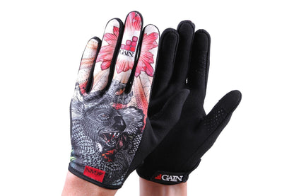 Displayed is a pair of GAIN Protection Resistance Skate Gloves - Dropbear. One glove showcases a vibrant design featuring a koala and pink flower, while the other is black with an ARMORTEX fabric textured grip. Both gloves prominently feature the "GAIN" brand, known for durability and touchscreen compatibility.