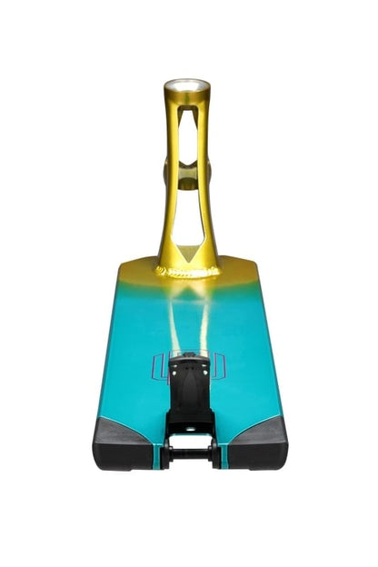 A metallic turquoise and gold ski boot binding is showcased from the front, featuring a sleek and modern limited edition design with black accents at the base. Its style echoes the striking appearance of the Blunt Envy AOS V5 LTD Raymond Warner Signature Stunt Scooter Deck - 5.5" x 21".