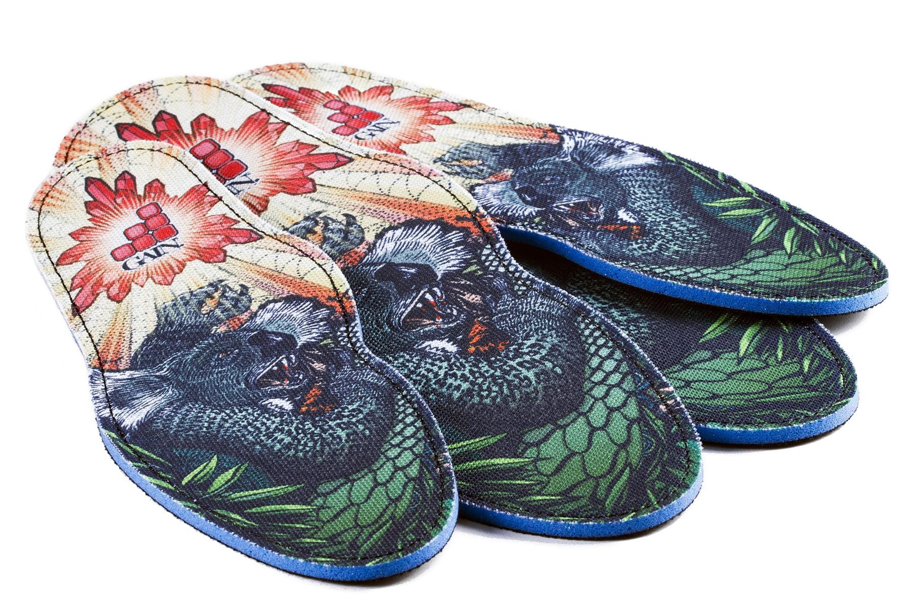 A pair of vibrant GAIN Protection SoleBros insoles in the Dropbear design, offering colorful shock absorption and eye-catching artwork featuring a gorilla's face, lush green leaves, and red flowers. The text "ENERTOR" is displayed prominently at the top. Ideal for freestyle scooter or BMX enthusiasts, these insoles are finished with blue edging along the sides.