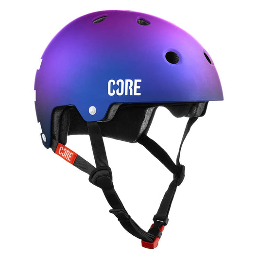 The CORE Street Skate/Scooter Helmet in Neo/White showcases a striking purple and blue gradient design with the "CORE" logo stylishly displayed on the side. This helmet is equipped with numerous ventilation holes, an adjustable black chin strap featuring a red buckle, and optional Lux Pads for improved comfort.