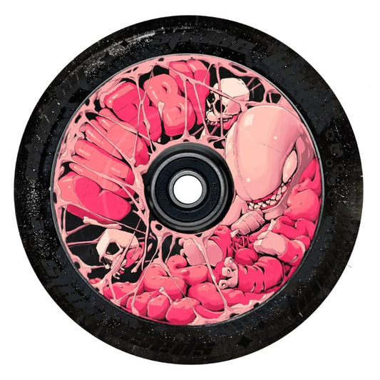 A close-up of the Chubby Baby Alien Gummy 110mm Hollowcore Stunt Scooter Wheel in Glitter Black / Pink showcases a pink and black design with a cartoonish creature that has sharp teeth, similar to a chubby baby alien, set against tangled web-like patterns.