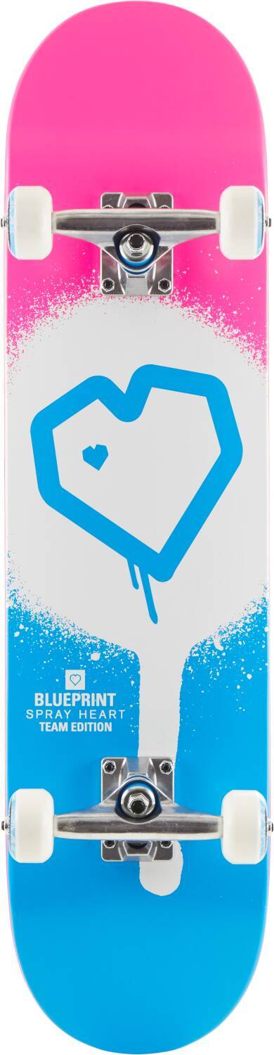 The Blueprint Spray Heart V2 Pink / Blue Complete Skateboard is ideal for beginner skaters, featuring a pink and blue gradient design with a white geometric heart and a smaller heart inside. It comes equipped with 99A wheels and displays the "BLUEPRINT SPRAY HEART TEAM EDITION" text at the bottom.