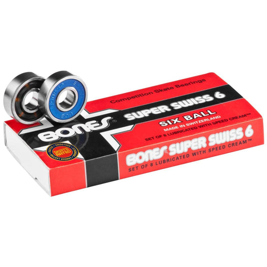 A package of Bones Super Swiss 6 Skateboard Bearings - 8 Pack, prominently featuring the bold "Six Ball" text. Two skateboard bearings are displayed on top, with one showcasing a noticeable blue shield. The predominantly red and black packaging exudes an aura of high-speed performance.