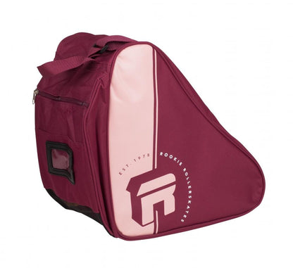 The Rookie Retro Roller Skate Bootbag in purple flaunts a unique triangular design ideal for transporting roller skates. It showcases "Rookie Rollerskates" along with "Est. 1978" printed on the side and is equipped with a shoulder strap, handle, side pocket, label slot, and a vented carry compartment for enhanced airflow.