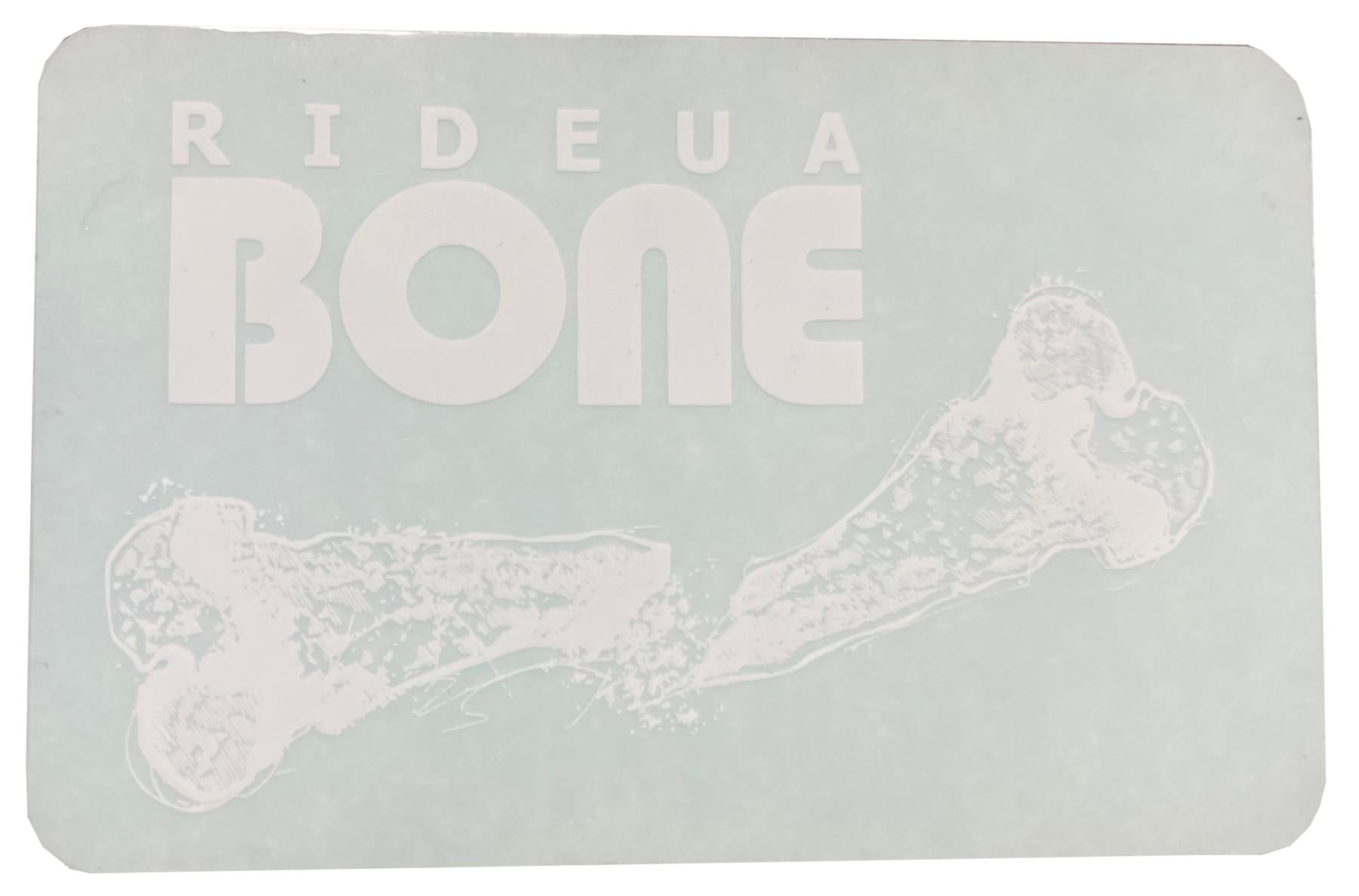 A rectangular sign featuring the bold, white UrbanArtt logo "RIDEAU BONE" set against a light blue background captures the essence of UrbanArtt's scootering vibe. Accompanying the text is a stylish, white illustration of a bone, echoing the design of the UrbanArtt Bone Sticker - White, making it an ideal choice for scooter enthusiasts.