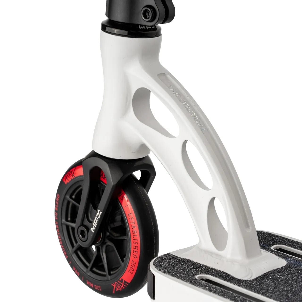 Close-up of the Madd Gear MGP VX Origin Team Edition Complete Stunt Scooter in White / Mandarin, highlighting its front wheel and suspension. The sturdy black wheel with red accents is secured to a lightweight white fork featuring distinctive oval cutouts. The scooter's deck, designed for performance and style, showcases a textured grip surface.