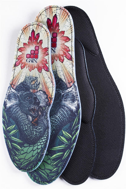 Introducing GAIN Protection SoleBros Insoles - Dropbear: vibrant and stylish insoles designed with freestyle scooter riders in mind. Featuring a colorful design of a gorilla amidst vivid flowers and foliage, these insoles incorporate shock-absorbing technology to ensure impact energy absorption. The iconic GAIN logo is prominently displayed at the top, while the reverse side is a sleek black.