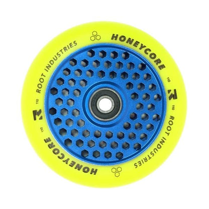 The Root Industries Honeycore 110mm Stunt Scooter Wheel showcases a blue honeycomb-patterned core paired with a striking yellow tire, incorporating Ultra High Rebound technology. The words "Honeycore" and "Root Industries" are prominently displayed on the tire, ensuring smooth performance thanks to ABEC 11 Bearings.