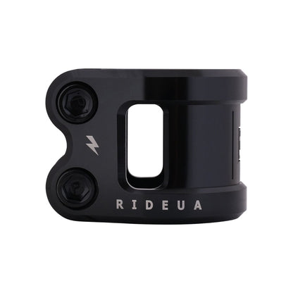 The UrbanArtt Civic 2 Bolt Oversized Stunt Scooter Clamp in black, crafted by UrbanArtt, features a sleek and modern design. It is the ideal choice for style-focused riders, with two bolts on the left and adorned with a lightning bolt symbol alongside the "RIDEUA" text.