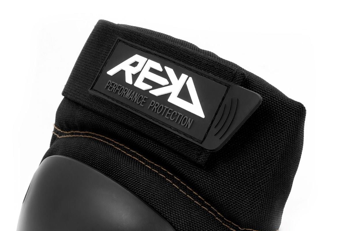 A close-up of a black protective glove featuring a hard knuckle guard, ideal for action sports. The strap displays the label "REKD Performance Protection." Made from durable material, this glove offers exceptional impact resistance and pairs perfectly with REKD's Ramp Knee Skate Protection Pads in Black/Khaki for comprehensive protection.