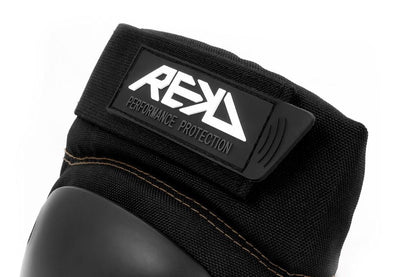 A close-up of a black protective glove featuring a hard knuckle guard, ideal for action sports. The strap displays the label "REKD Performance Protection." Made from durable material, this glove offers exceptional impact resistance and pairs perfectly with REKD's Ramp Knee Skate Protection Pads in Black/Khaki for comprehensive protection.