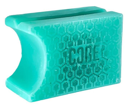 A Bubblegum Teal plastic tool from CORE, featuring a hexagon pattern and a curved central opening, is optimized with CORE Epic Skate Wax for smooth gliding.