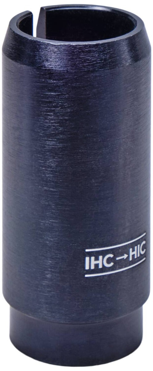 Close-up of the Dial 911 IHC-HIC Scooter Conversion Shim, a dark metal cylindrical object essential for a smooth stunt scooter setup. It features a "IHC → HIC" marking, smooth texture, and a vertical slit on one side, making it ideal for IHC forks in your scooter conversion.