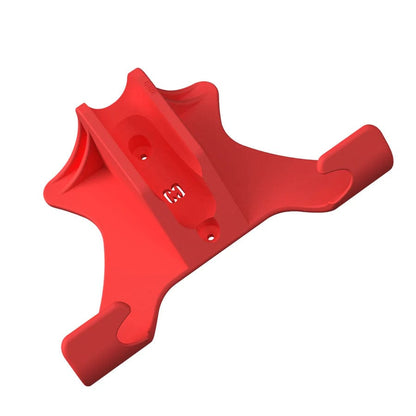 Introducing the CORE Scooter Wall & Floor Stand by CORE, a distinctively designed red plastic holder featuring a central cavity for attachment and two extended arms. This adaptable wall stand boasts an array of curves and angles, complete with visible surface markings.