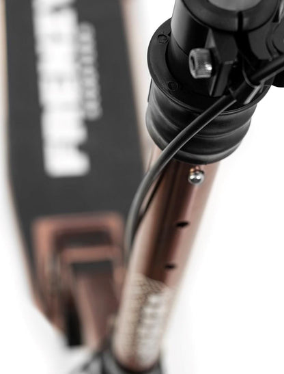 Close-up view of the handlebar and stem of the Frenzy 205mm Dual Brake V4 Foldable Commuter Scooter in Bronze, highlighting its sleek metallic design with visible wiring. The scooter’s deck prominently displays the logo, while the blurred background emphasizes its impressive cable folding system.