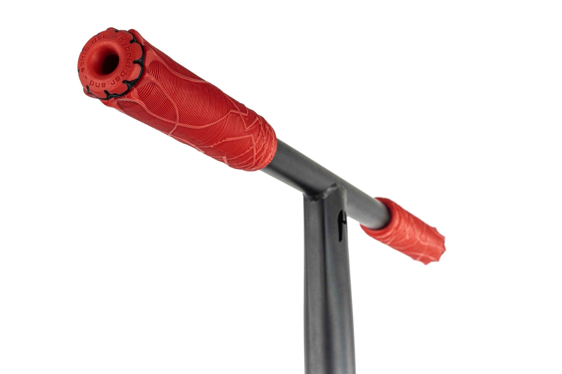 Close-up of the Ethic DTC Pandora Complete Stunt Scooter (L) handlebar, featuring textured red grips with a floral pattern on a chromoly steel T-bar. The decorative grips elegantly complement the robust black metal frame, making it ideal for street riding enthusiasts.