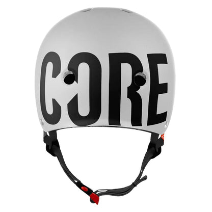 The CORE Action Sports Skate/Scooter Helmet is a stylish helmet in white, adorned with prominent black letters spelling "CORE" on the front. Engineered for both comfort and aesthetics, it includes ventilation holes and an adjustable black strap with a red buckle.